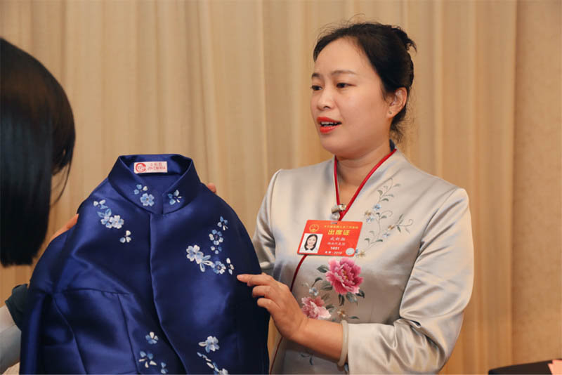 成新湘向中国文明网记者展示湘绣服饰。中国文明网记者邓植尹摄