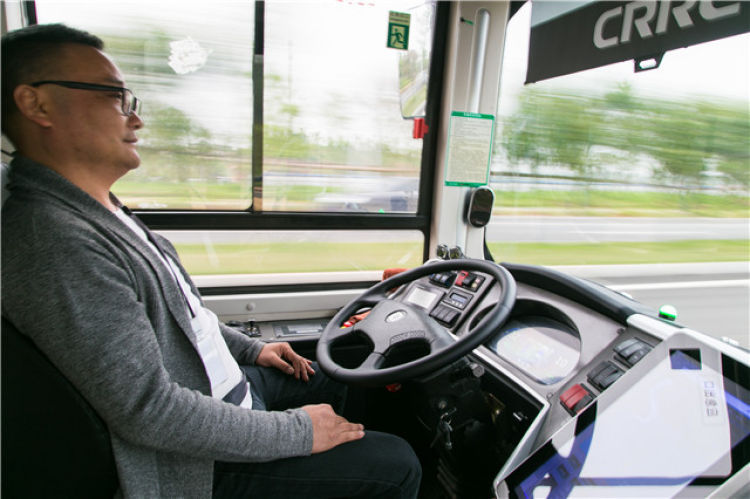 一辆无人驾驶公交车在国家智能网联汽车（长沙）测试区内行驶，驾驶座位的测试员关注路况和驾驶数据（4月28日摄）。新华社发（陈思汗摄）