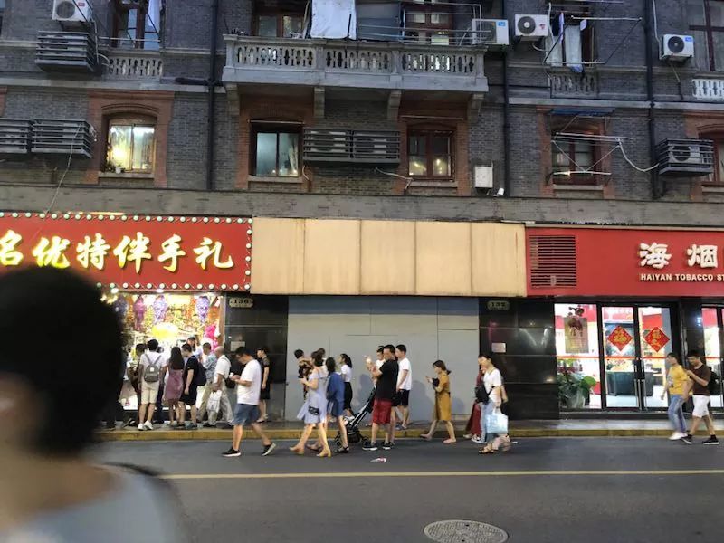 8月15日晚上7点，南京东路步行街人流如织。涉事店铺的招牌和大门，都被用木板封了起