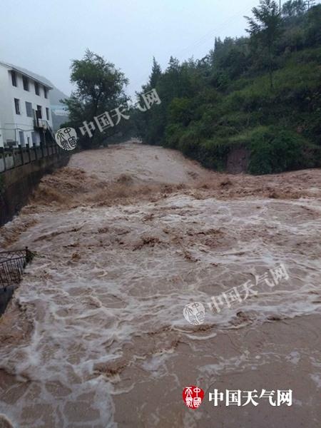 昨天，万源市八台镇桅杆坪村洪水将道路淹没。（图/夏菲）