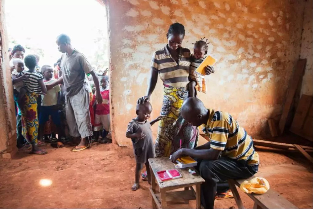 一位刚果母亲带着她的孩子在村里的教堂打疫苗。