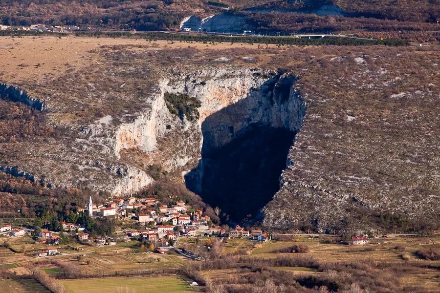 洞穴与岩壁旁的喀斯特地区小镇。图片来源：lovenia-trips.com