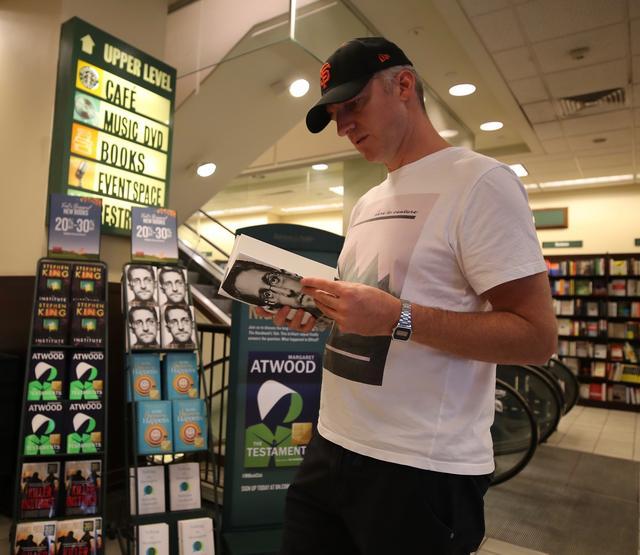 美国纽约的一家书店里，一名顾客正在翻阅斯诺登的新书 / 视觉中国